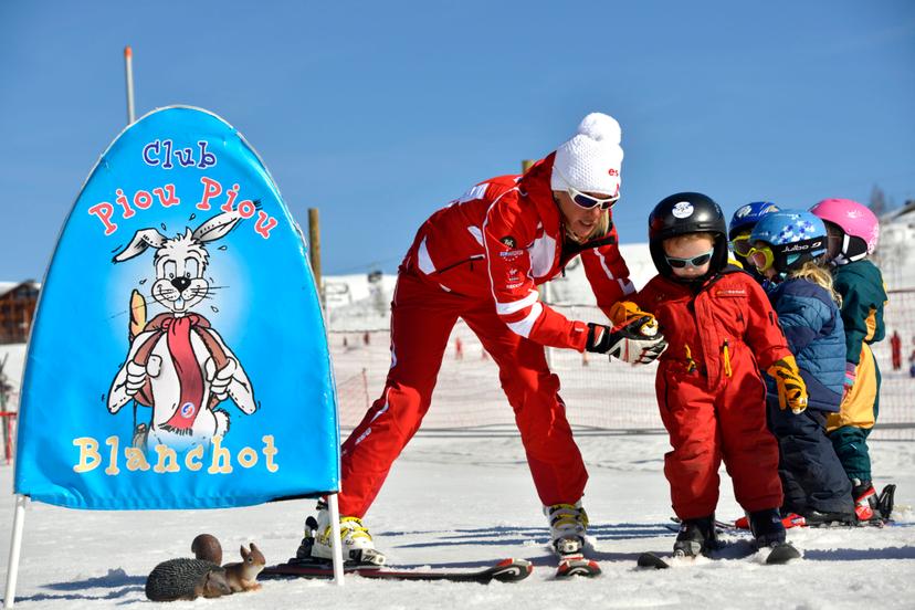 Ski instructor showing children how to ski in Alpe D'Huez ski resort